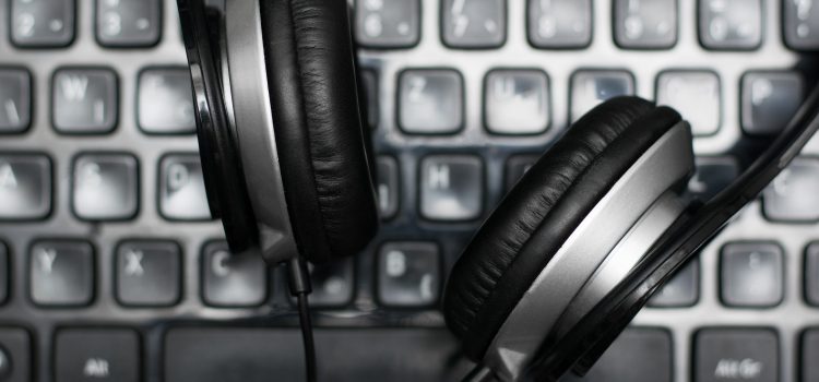 Headphones on laptop keyboard to edit audio