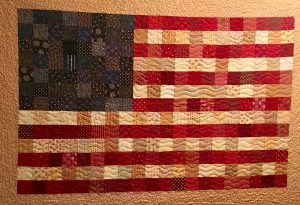 Quilt of a United States flag made by Becky Lockhart and hanging in their home. She made many quilts and gave them to loved ones. 