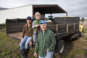 Become a business storyteller using these 5 questions. Family businesses, such as this 3 generation family farm, are especially important organizations to share stories. This photo shows 3 generations of men on the back of a truck on the family farm. They are wearing jeans, work boots and jackets or flannel shirt.