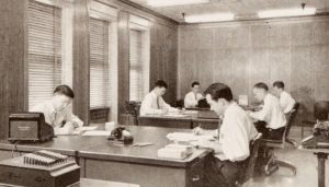 Men doing office work in the 1940s. Maybe their responsibilities included transcribing audio to text with a dictaphone. What do you think?