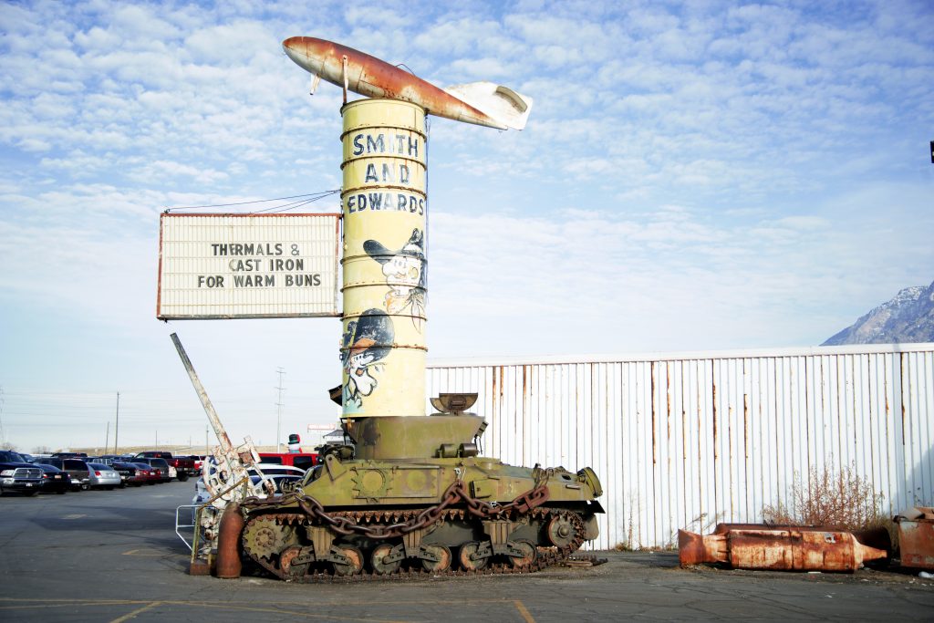 Bert Smith who founded Smith and Edwards told about a time when he almost died in an accident. Photo of the tank and sign outside Smith and Edwards.