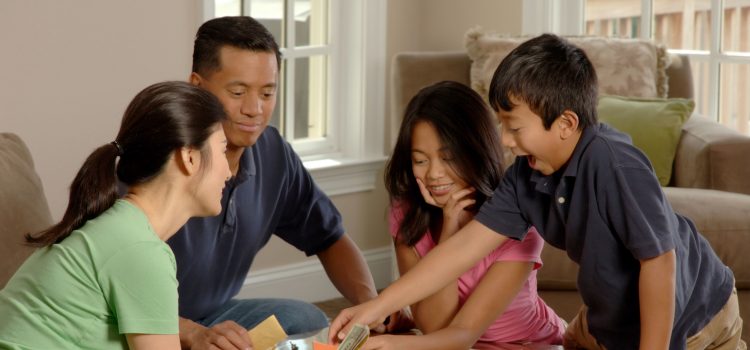 Remember who you are - family putting away technology and playing monopoly
