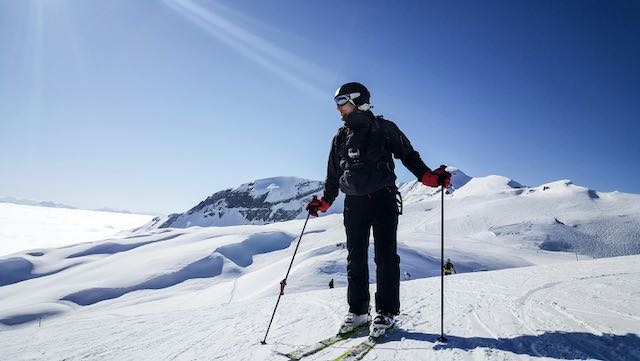Man cross country skiing in the sunshine. Getting some sun and exercise and nature are key ways to battle seasonal blahs.